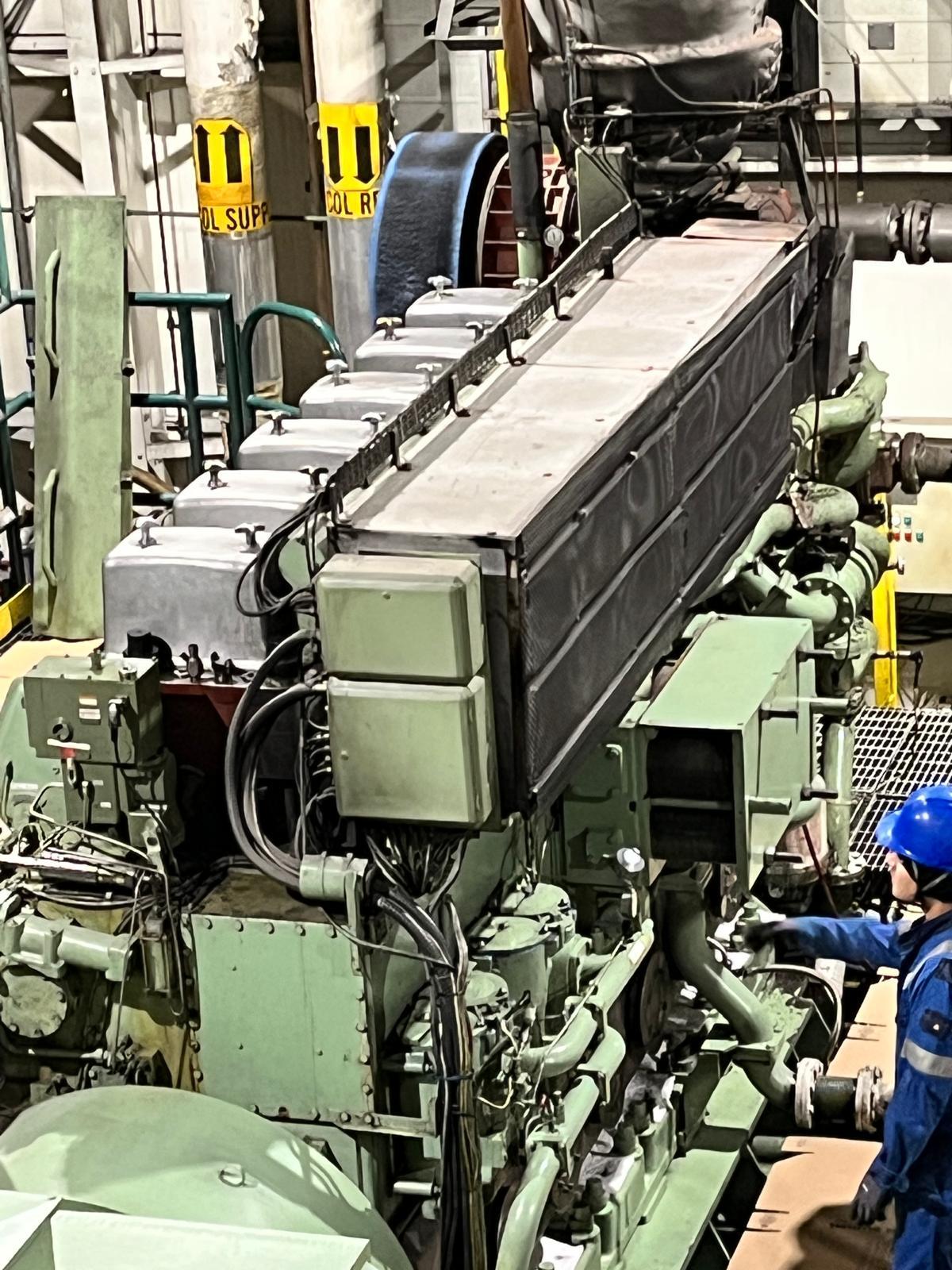 Auxiliary marine engine and engineer in the engine room